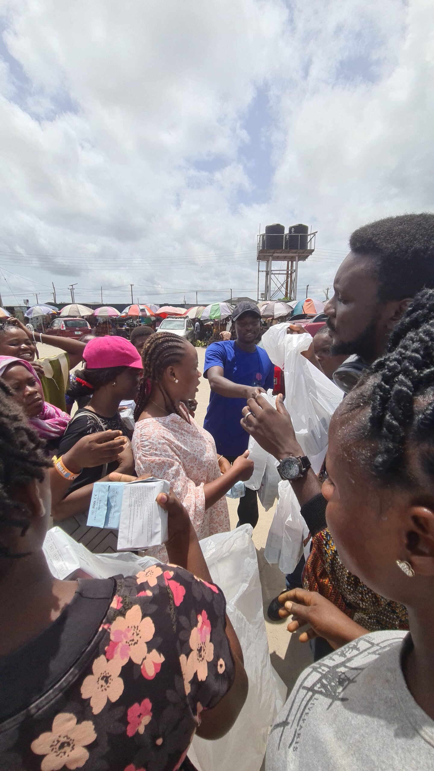 Volunteers and community members participating in Blossomflow Foundation’s community outreach at Elesekan Market, distributing sanitary products to girls and women.