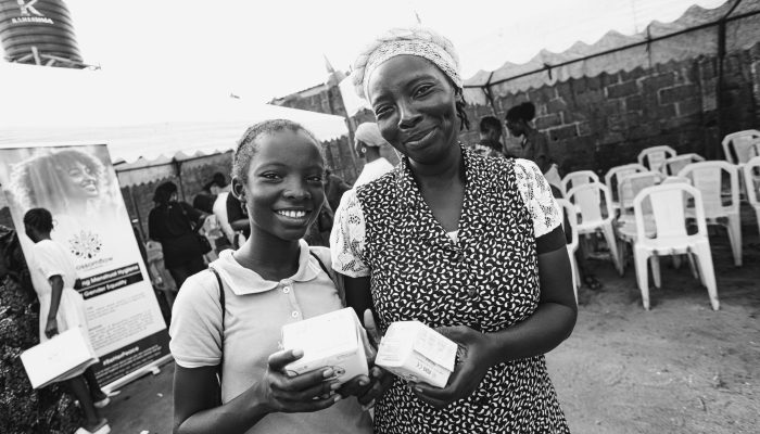 Mother and child at BlossomFlow Foundation outreach, receiving menstrual education and supplies